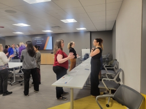 Members chat at tables and around the room at this year's New Member orientation