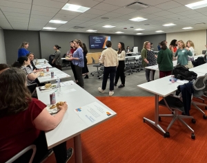 Members chat at tables and around the room at this year's New Member orientation